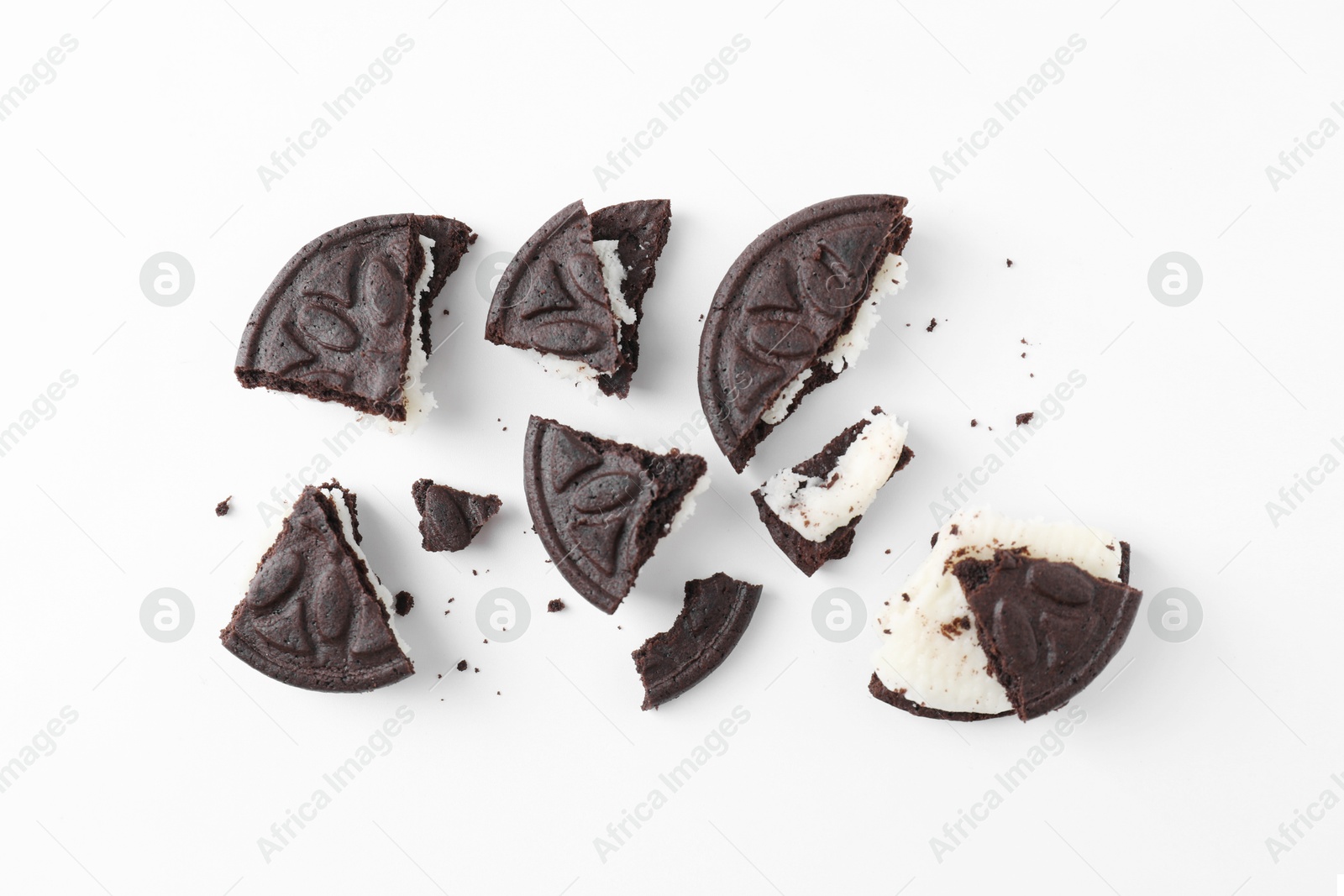 Photo of Broken tasty sandwich cookies on white background, flat lay