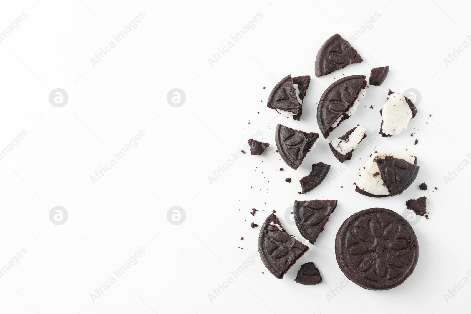 Photo of Whole and broken tasty sandwich cookies on white background, flat lay. Space for text