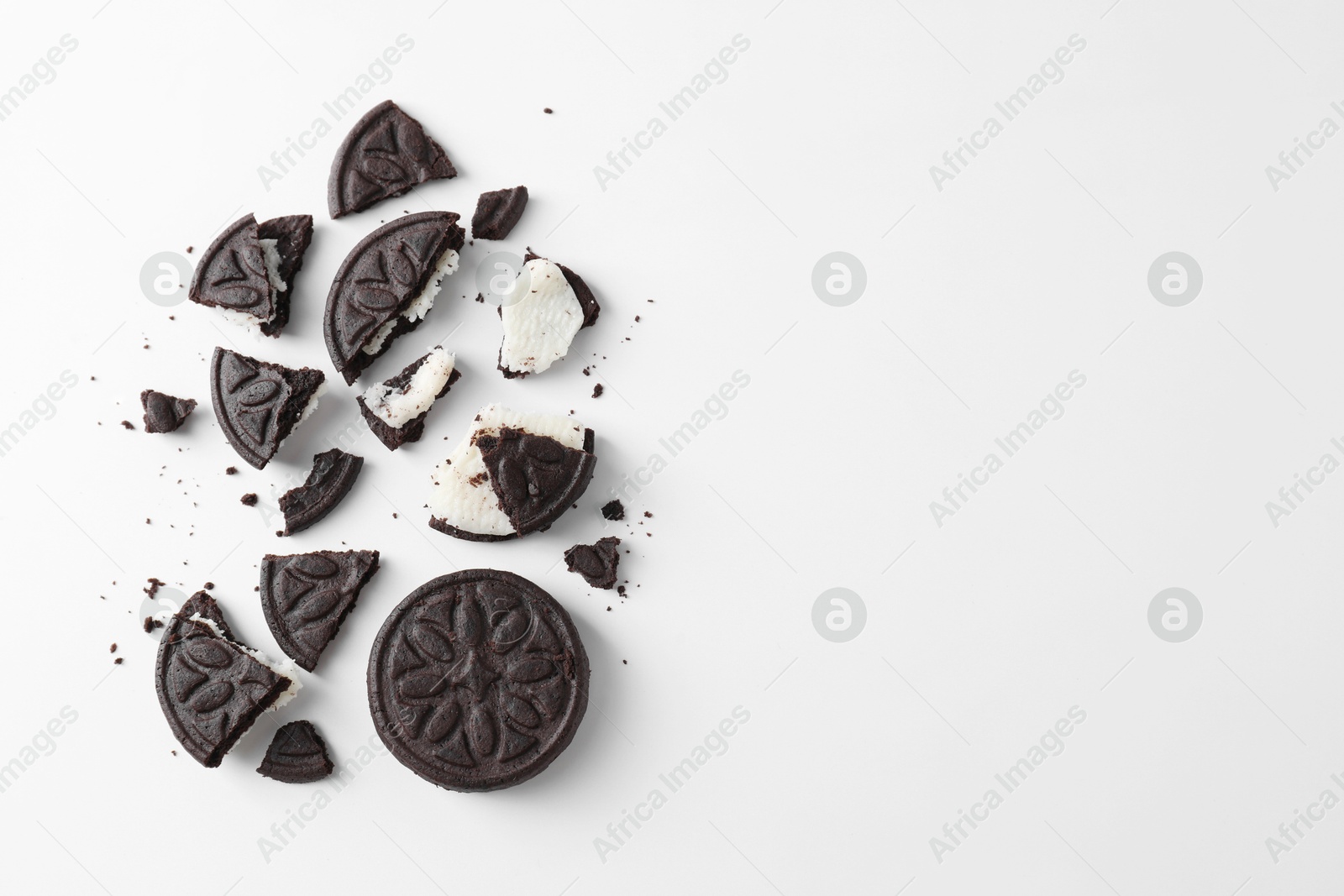 Photo of Whole and broken tasty sandwich cookies on white background, flat lay. Space for text