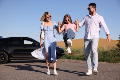 Photo of Parents, their daughter and car outdoors. Family traveling
