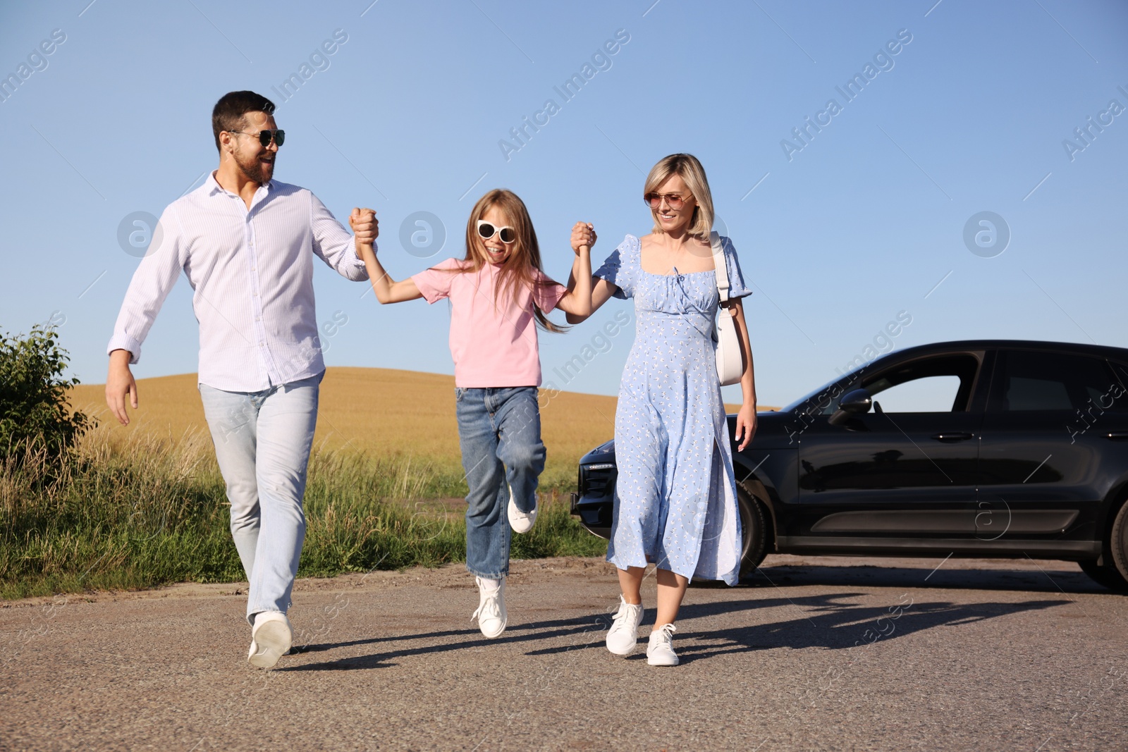 Photo of Parents, their daughter and car outdoors. Family traveling