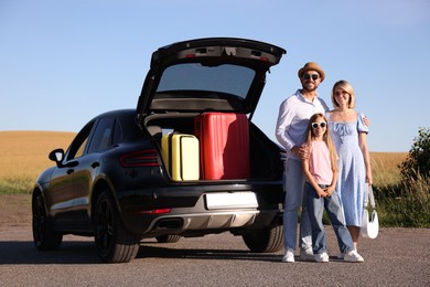 Photo of Happy family near car with suitcases outdoors
