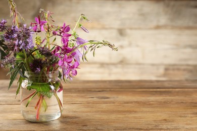 Bouquet of different healing herbs on wooden table. Space for text