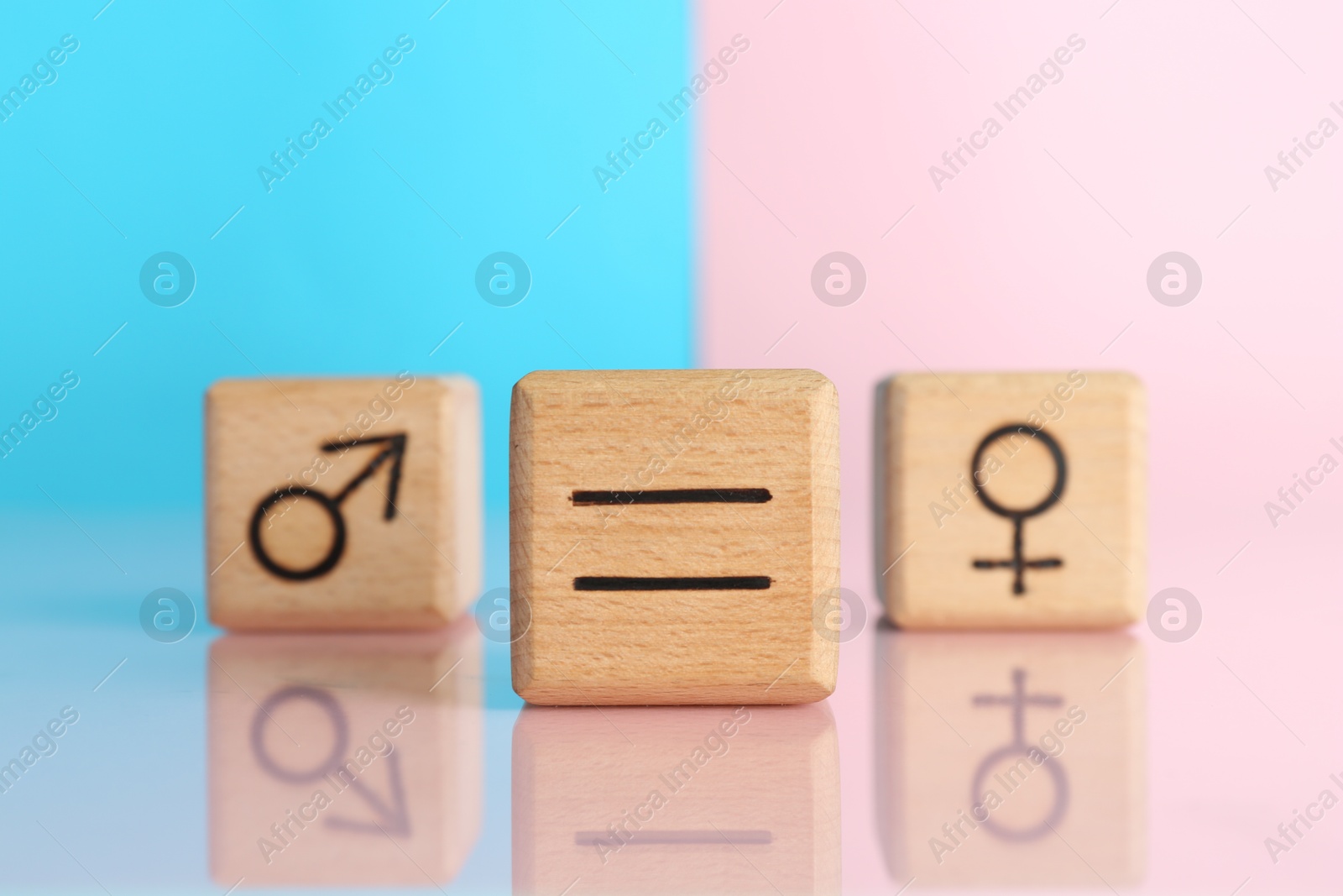 Photo of Gender equality concept. Cubes with male and female symbols on color background, selective focus