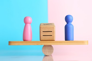 Photo of Gender equality concept. Cube with equals sign between male and female figures on scales against color background