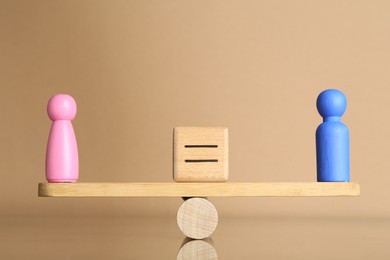 Photo of Gender equality concept. Cube with equals sign between male and female figures on scales against beige background