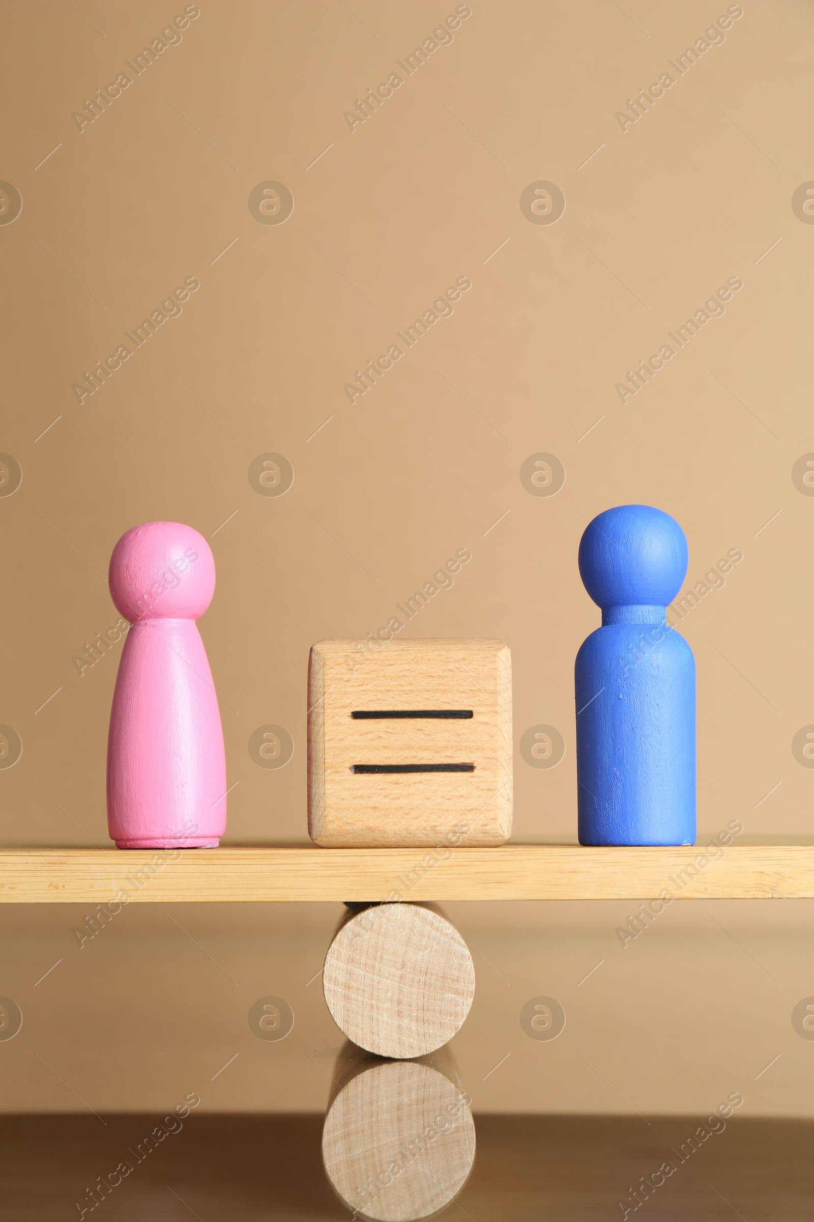 Photo of Gender equality concept. Cube with equals sign between male and female figures on scales against beige background