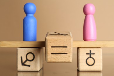 Photo of Gender equality concept. Cube with equals sign between male and female figures on scales against beige background