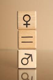 Photo of Gender equality concept. Cubes with male and female symbols on beige background