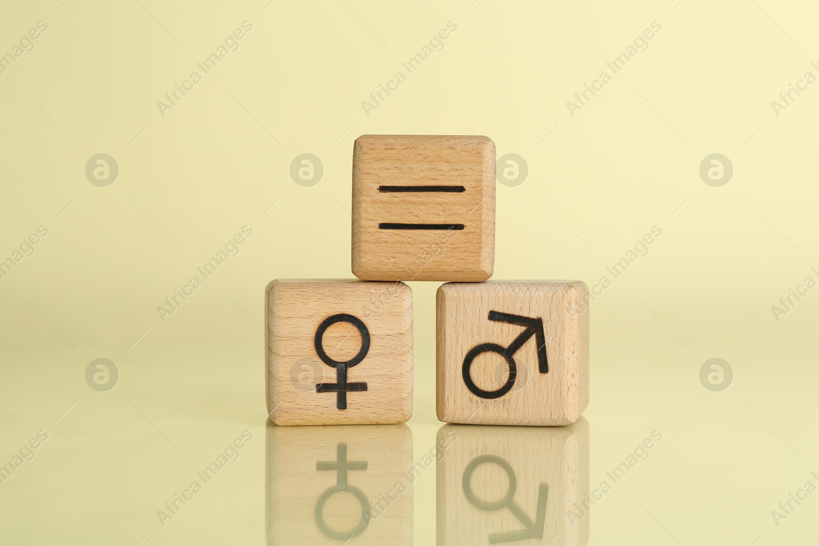 Photo of Gender equality concept. Wooden cubes with male and female symbols on light yellow background