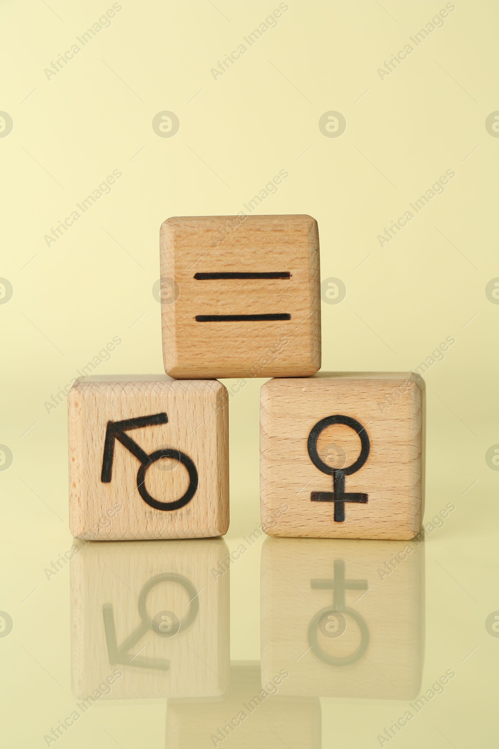 Photo of Gender equality concept. Wooden cubes with male and female symbols on light yellow background