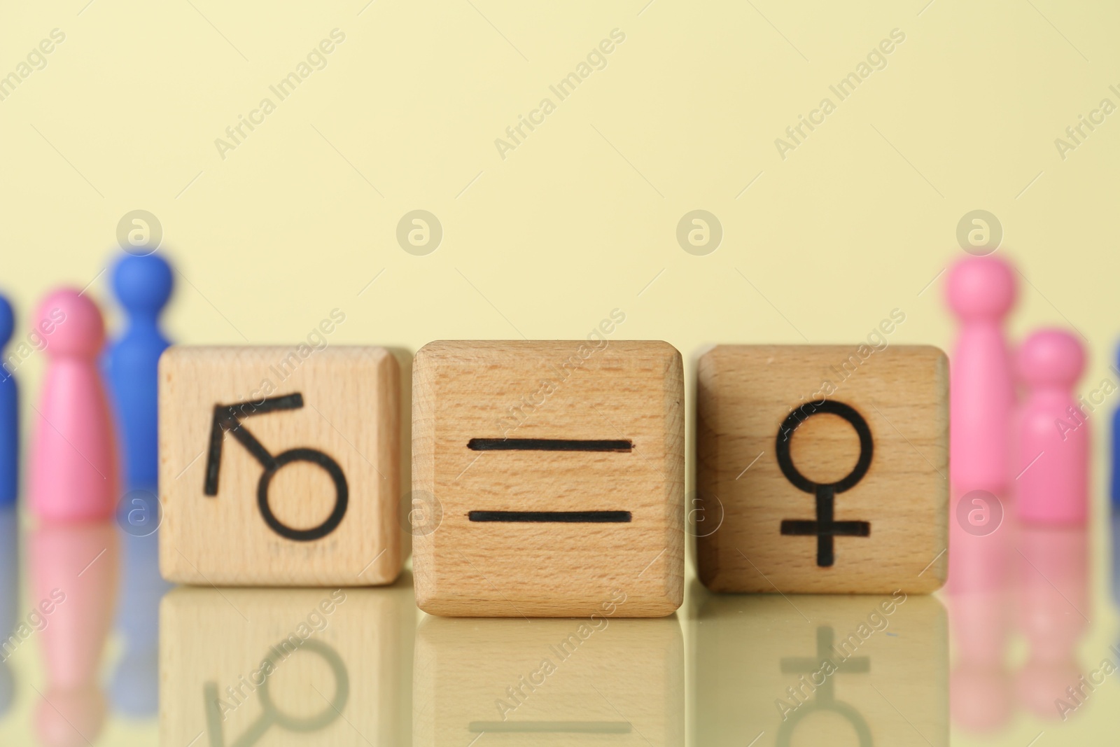 Photo of Gender equality concept. Wooden cubes with male and female symbols on light yellow background