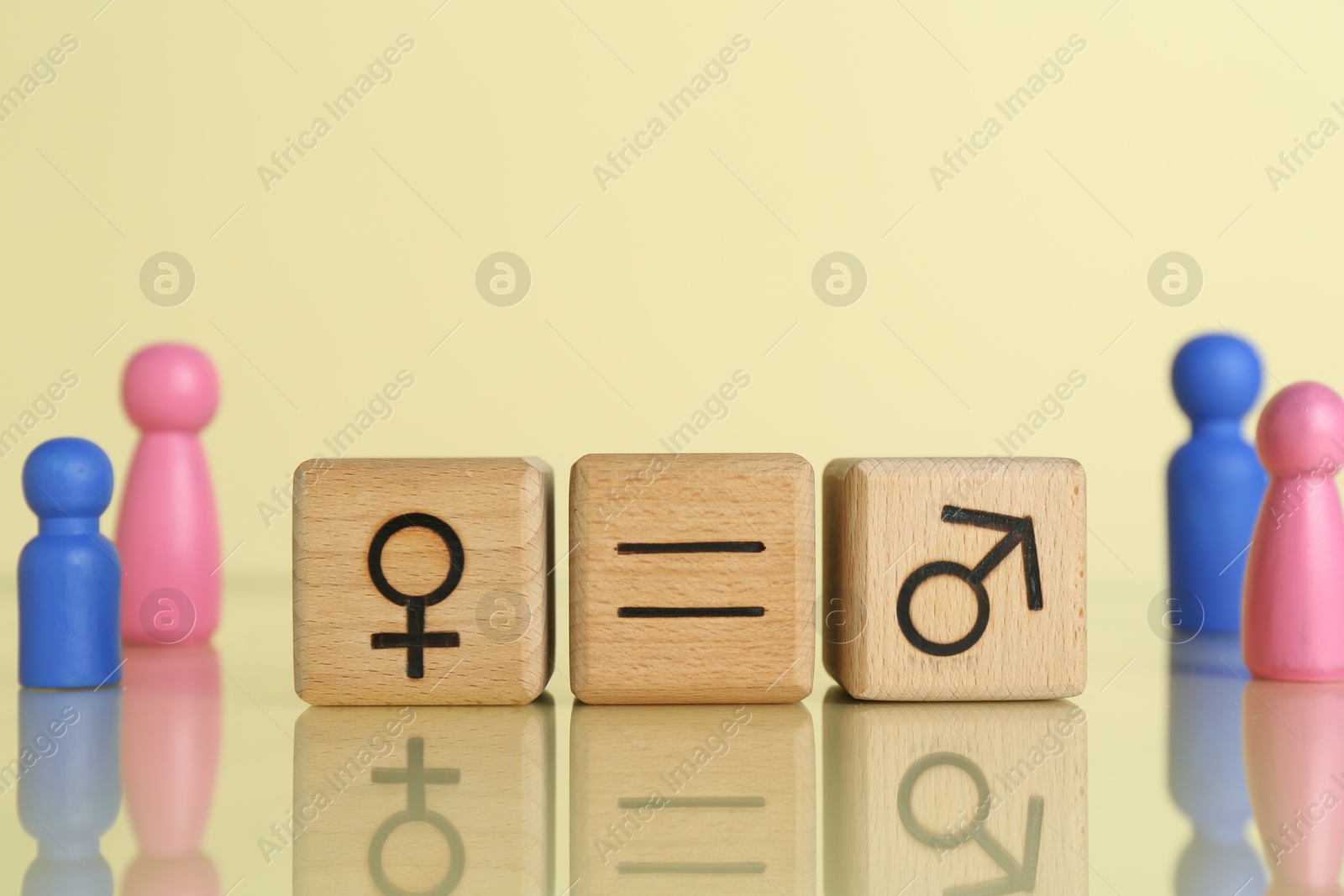 Photo of Gender equality concept. Wooden cubes with male and female symbols on light yellow background