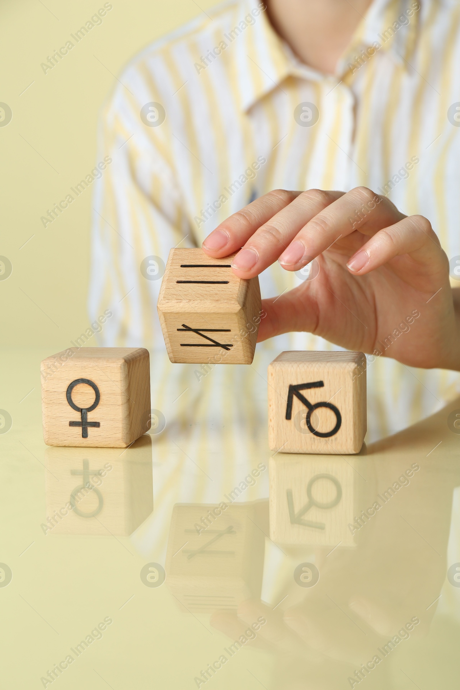 Photo of Gender equality concept. Woman with wooden cubes of male and female symbols at table, closeup