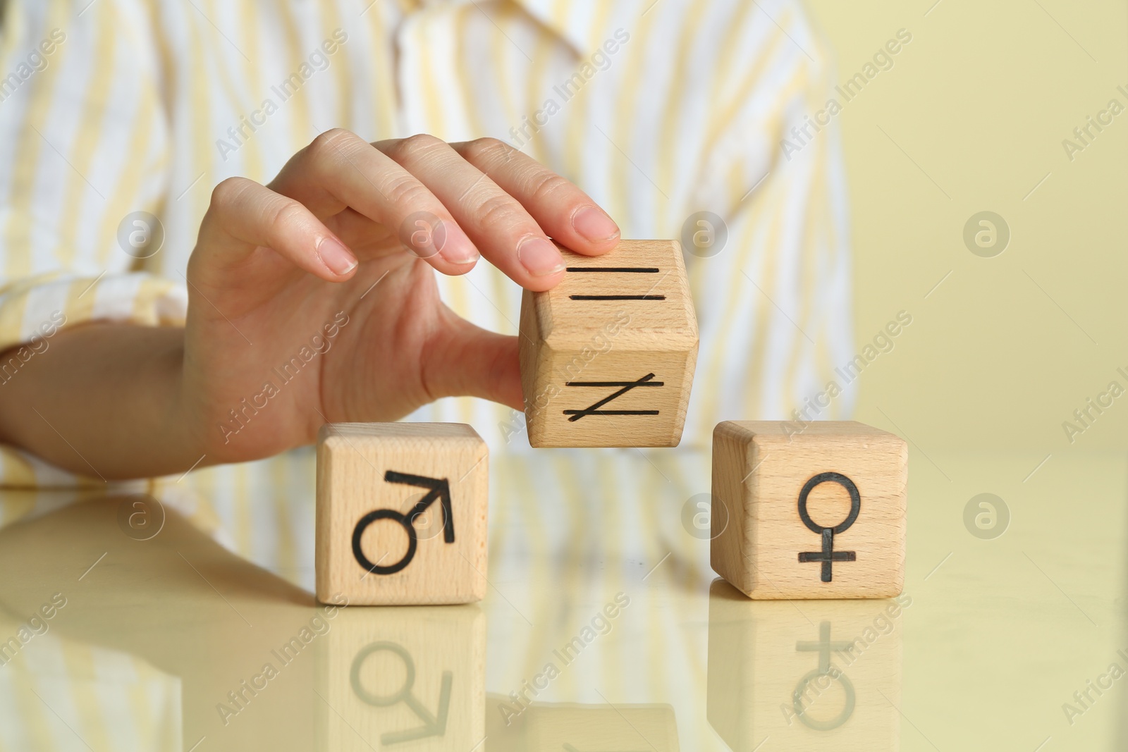 Photo of Gender equality concept. Woman with wooden cubes of male and female symbols at table, closeup