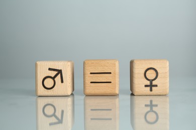 Gender equality concept. Cubes with male and female symbols on grey background