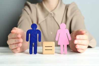 Photo of Gender equality concept. Woman with male and female figures at white table, closeup