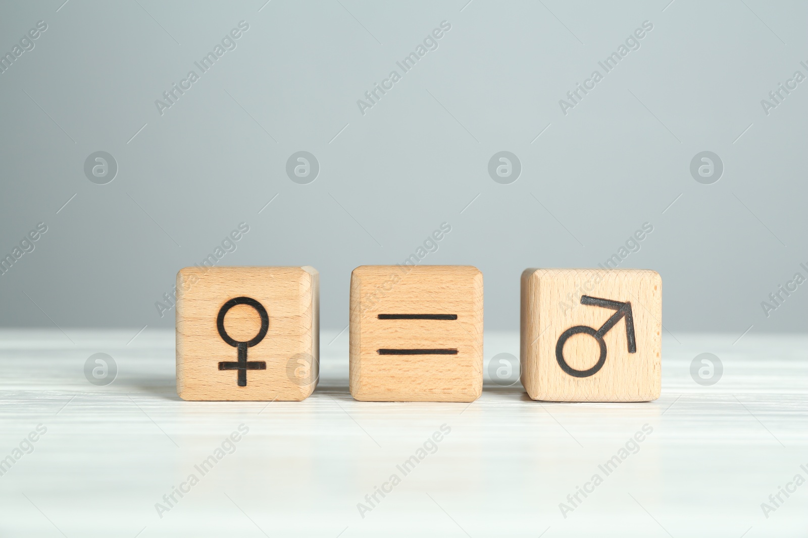 Photo of Gender equality concept. Cubes with male and female symbols on white table