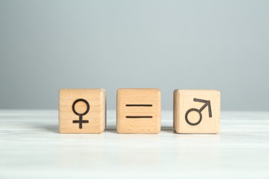 Photo of Gender equality concept. Cubes with male and female symbols on white table