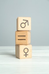 Gender equality concept. Cubes with male and female symbols on white table