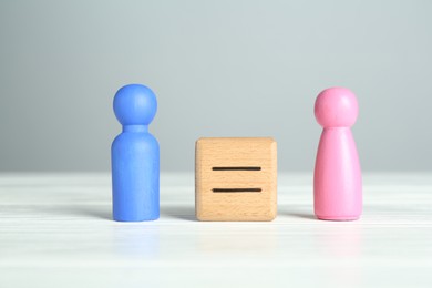 Photo of Gender equality concept. Cube with equals sign between male and female figures on white table