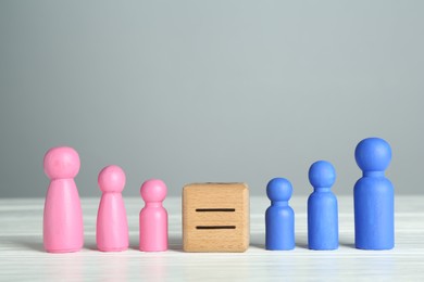 Photo of Gender equality concept. Cube with equals sign between male and female figures on white table