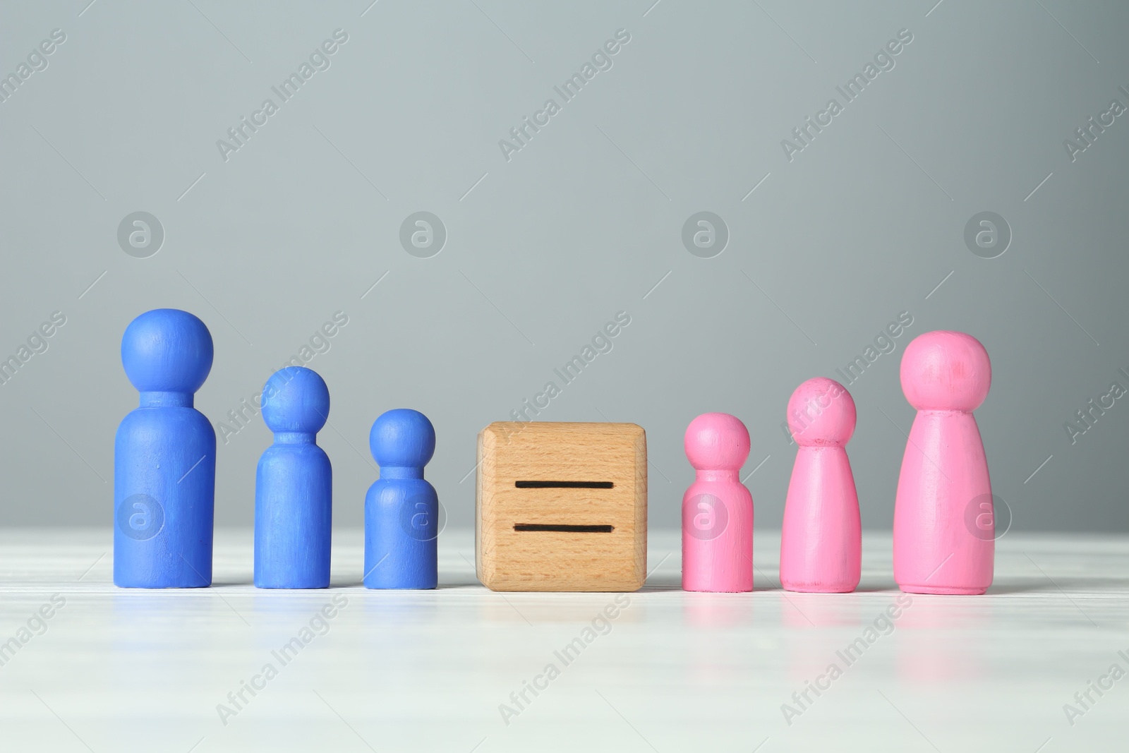 Photo of Gender equality concept. Cube with equals sign between male and female figures on white table