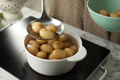 Photo of Taking potatoes from pot on stove, closeup