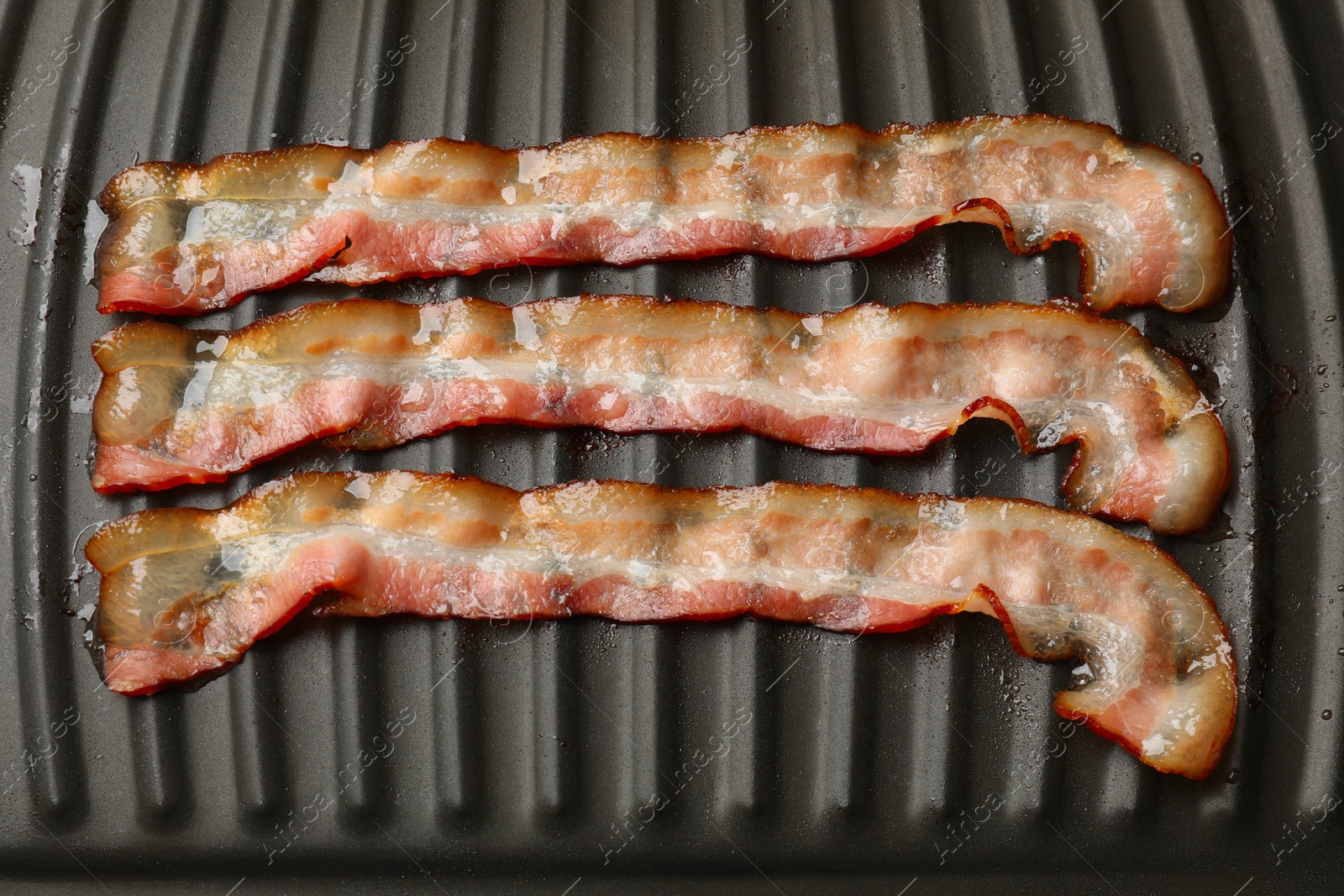 Photo of Slices of bacon on grill, top view