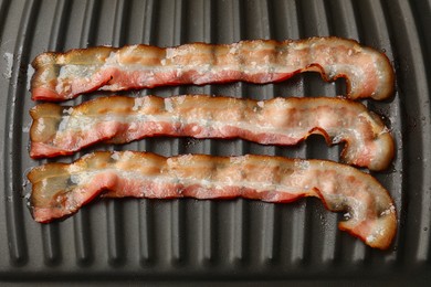 Photo of Slices of bacon on grill, top view