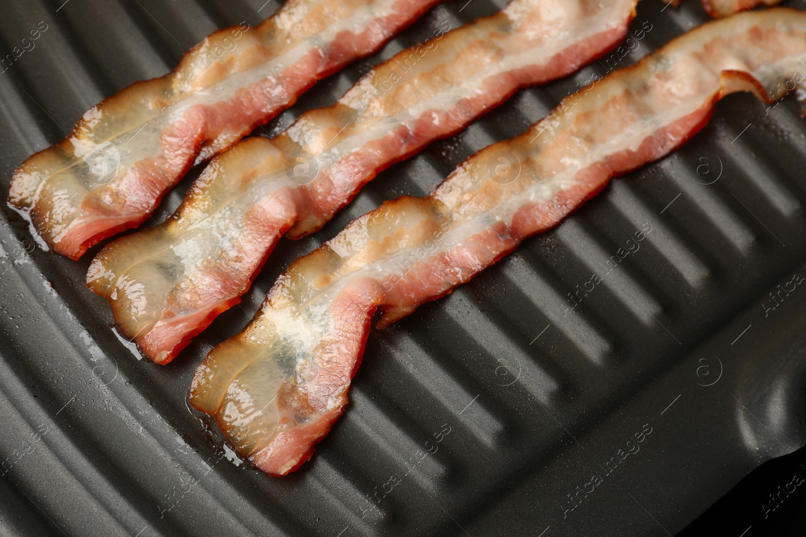 Photo of Slices of bacon on grill, closeup view