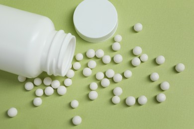 Photo of Homeopathic remedy and bottle on light green background