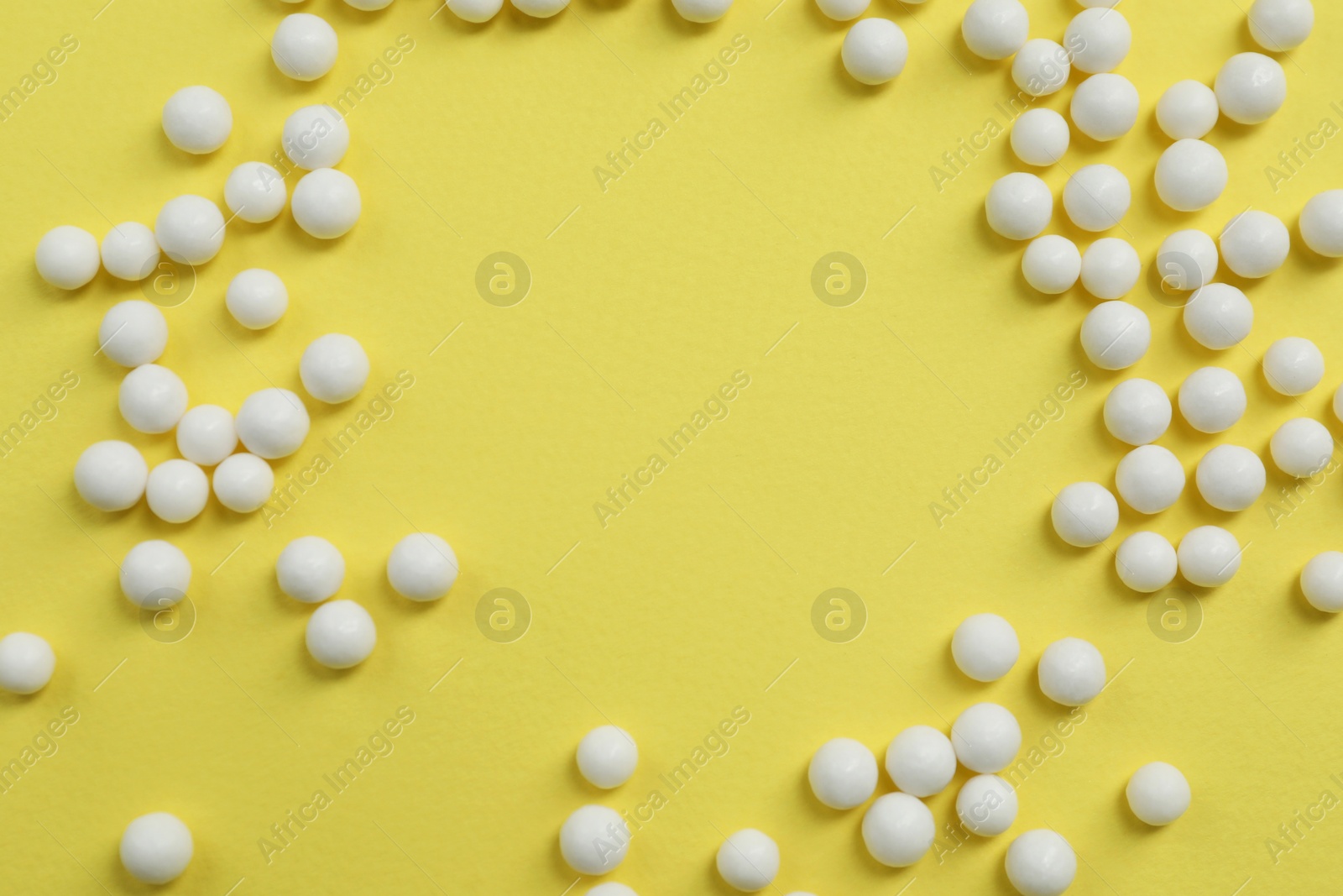 Photo of Homeopathic remedy on yellow background, flat lay. Space for text