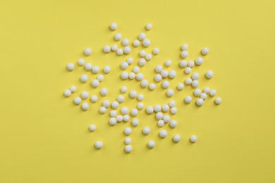 Photo of Homeopathic remedy on yellow background, flat lay