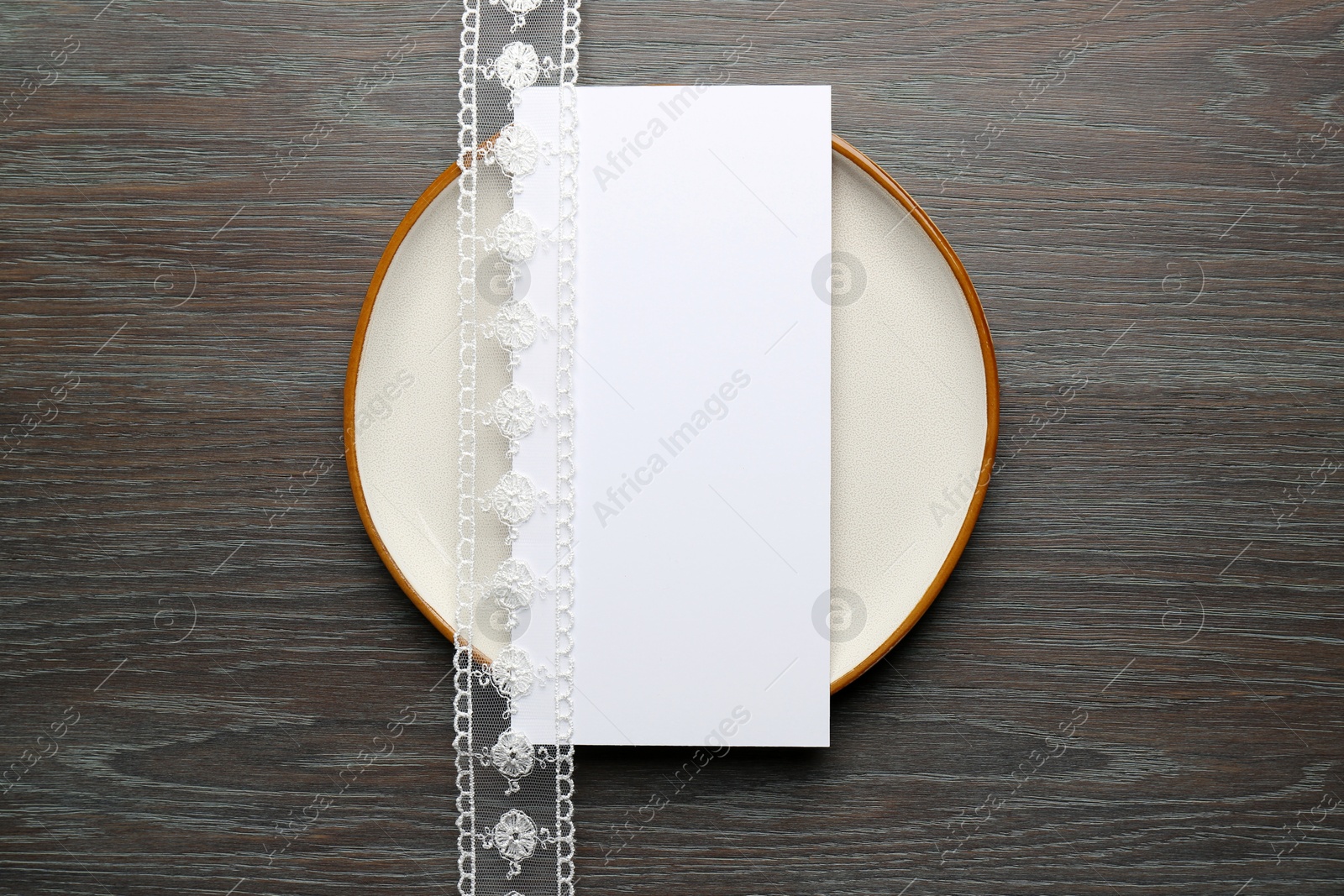 Photo of Empty menu, plate and beautiful ribbon on wooden table, top view. Mockup for design