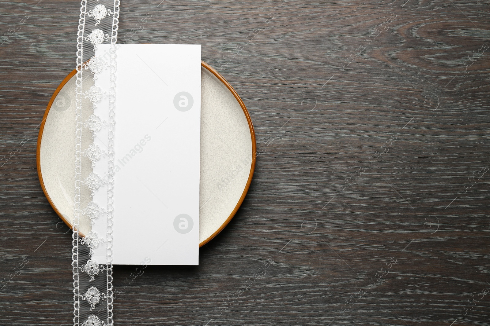 Photo of Empty menu, plate and beautiful ribbon on wooden table, top view. Mockup for design