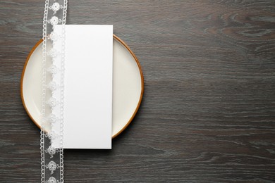 Photo of Empty menu, plate and beautiful ribbon on wooden table, top view. Mockup for design