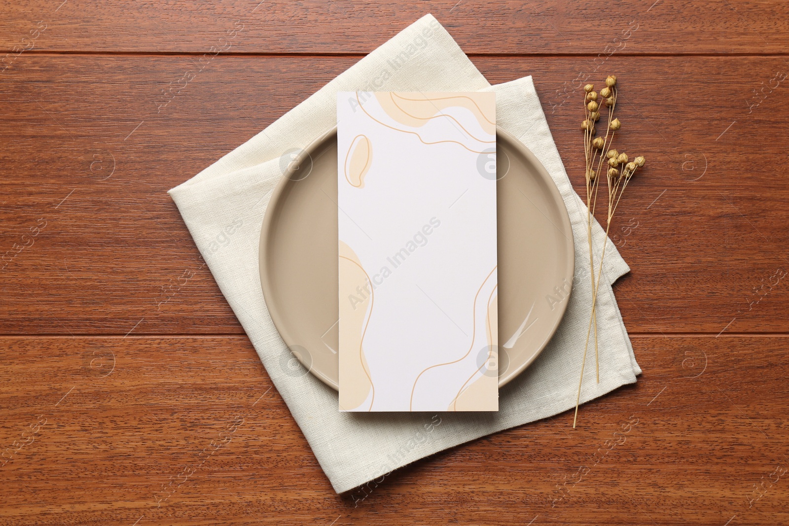 Photo of Empty menu, plate, napkin and dry flowers on wooden table, top view. Mockup for design