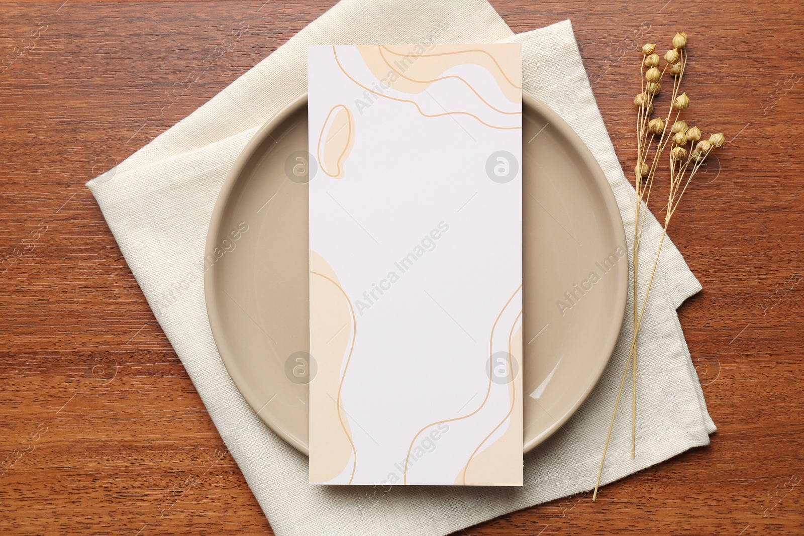 Photo of Empty menu, plate, napkin and dry flowers on wooden table, top view. Mockup for design