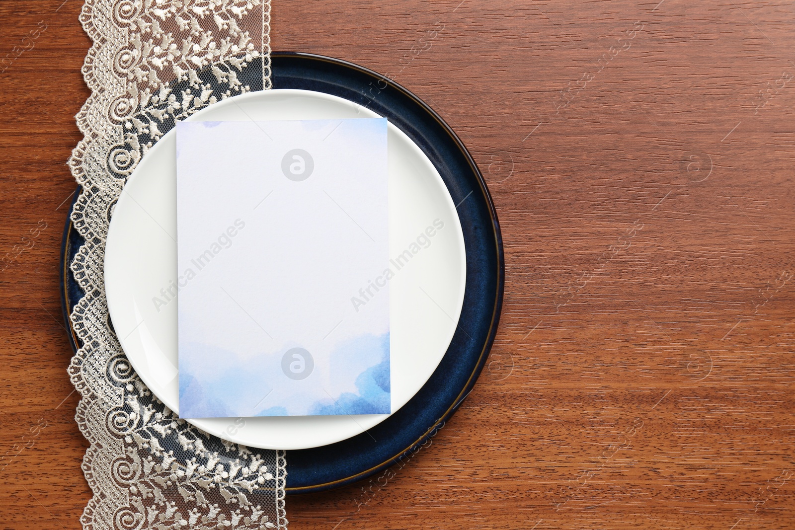 Photo of Empty menu and plates on wooden table, top view. Mockup for design