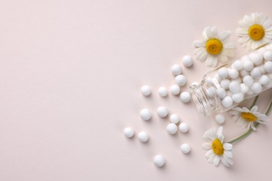 Photo of Homeopathy. Glass bottle, pills and chamomiles on beige background, top view. Space for text