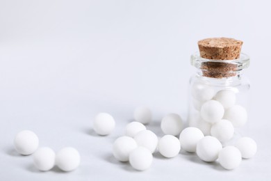 Photo of Homeopathy. Glass bottle and pills on white background, closeup