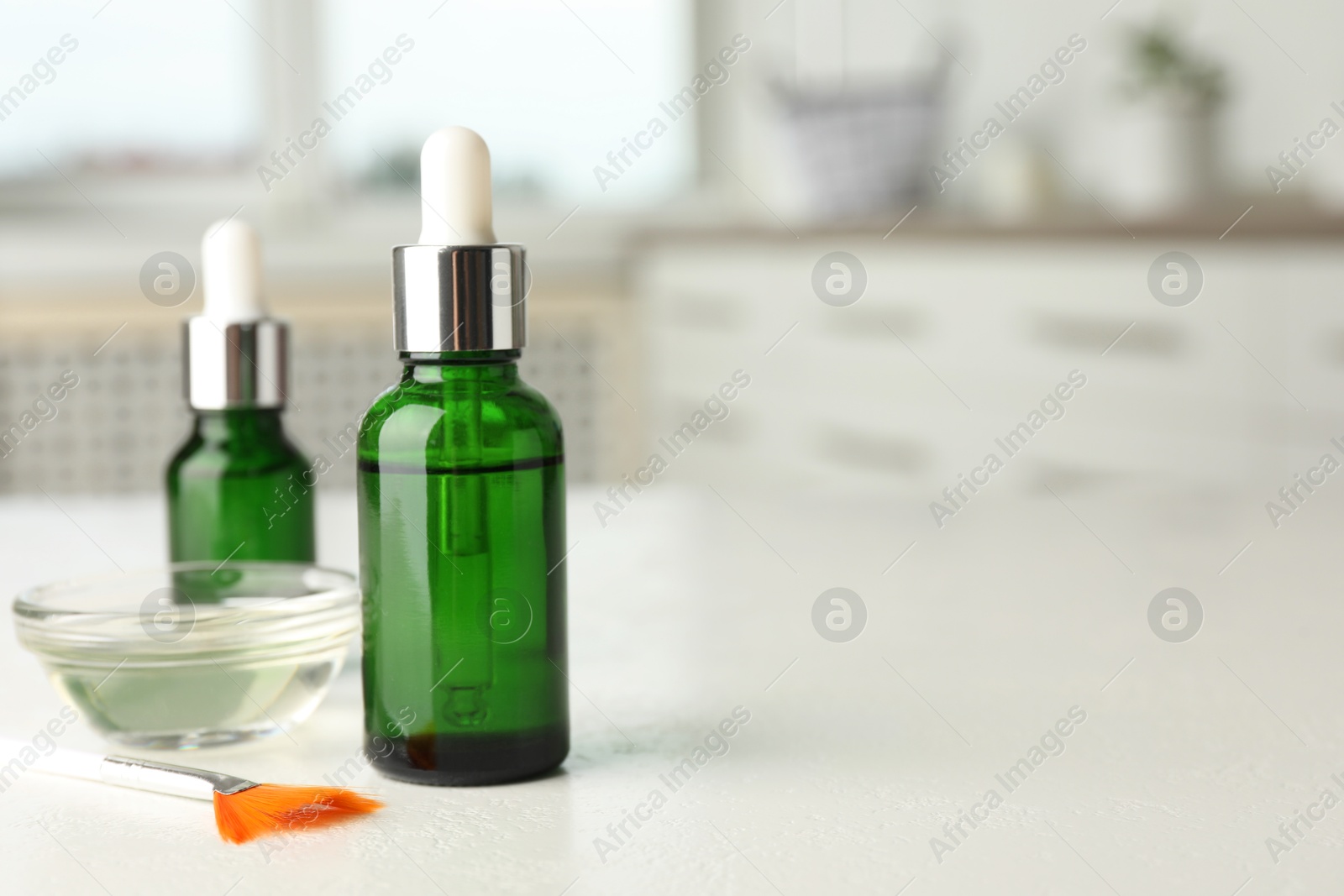 Photo of Peeling procedure. Bottles of chemical peel, bowl with liquid and brush on white table indoors. Space for text