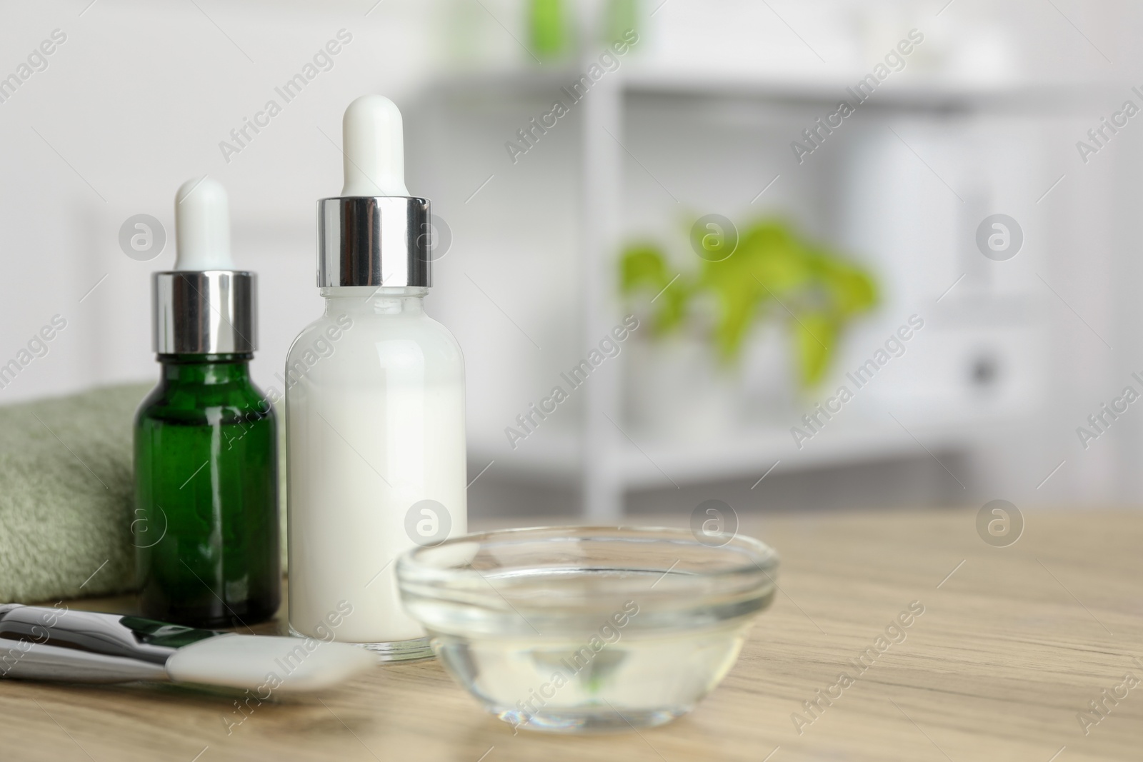 Photo of Peeling procedure. Bottles of chemical peel, bowl with liquid and brush on wooden table indoors. Space for text