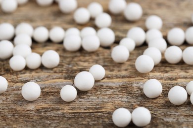 Photo of Homeopathic remedy. Many round pills on wooden table, closeup