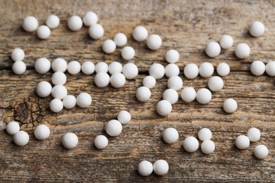 Homeopathic remedy. Many round pills on wooden table, closeup