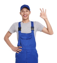 Photo of Smiling auto mechanic showing ok gesture on white background