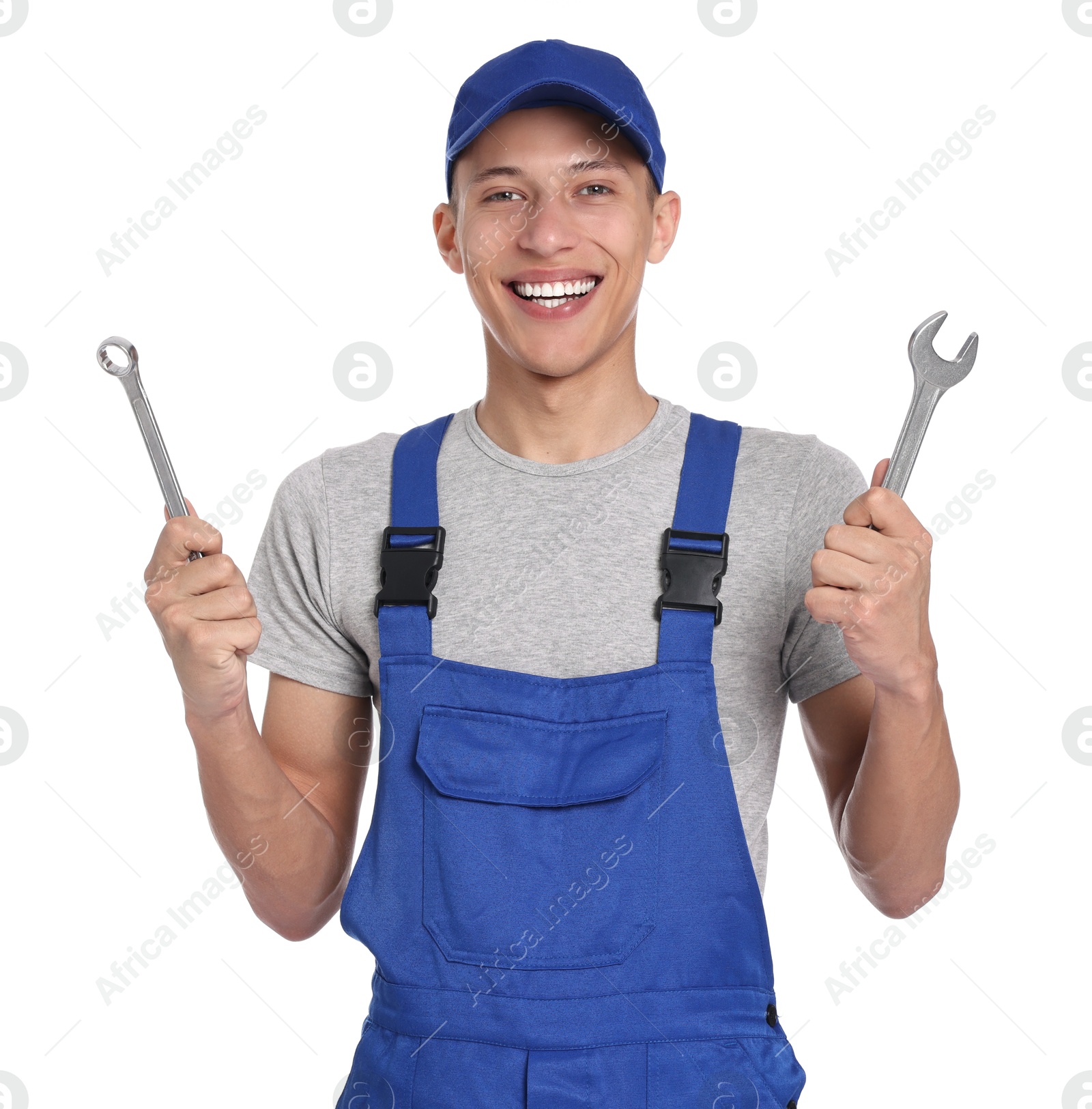 Photo of Smiling auto mechanic with wrenches on white background