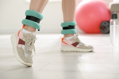 Woman with ankle weights in gym, closeup