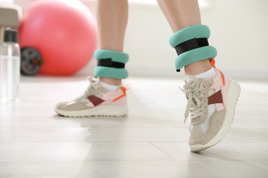 Photo of Woman with ankle weights in gym, closeup